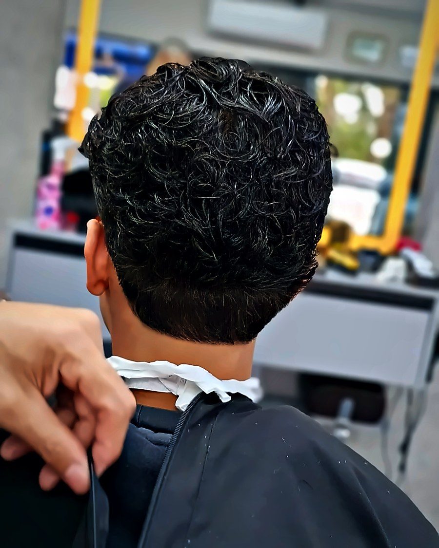 O barbeiro ajustando a capa antes do corte